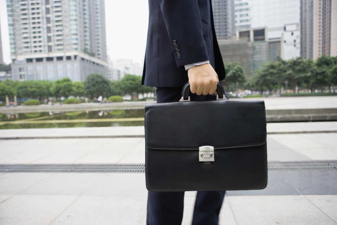 A man in suit is walking on pavements