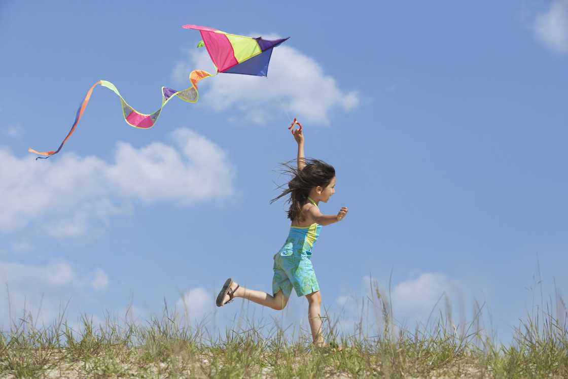 A Hispanic girl is flying a kite A Hispanic girl is flying a kite