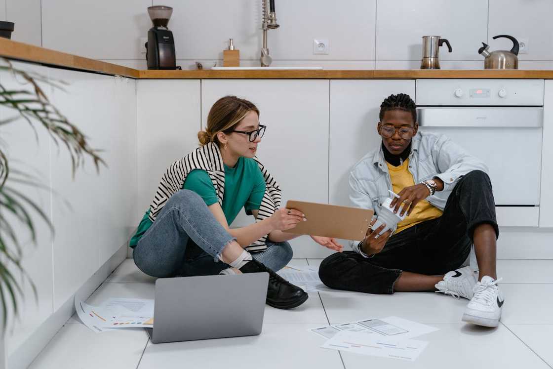 A man sits with his partner on the kitchen floor. A man sits with his partner on the kitchen floor.
