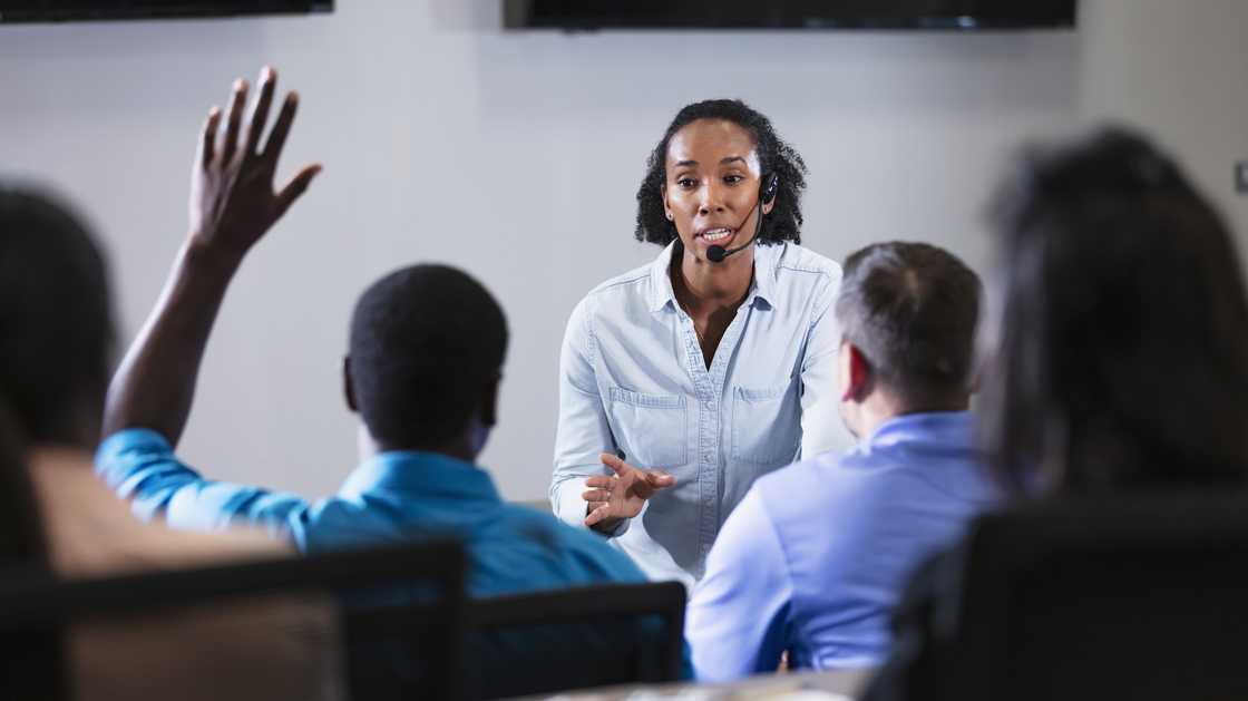 A coach stands before a group of call centre trainees during accent training.