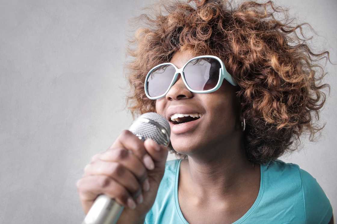 A woman holding a microphone for karaoke