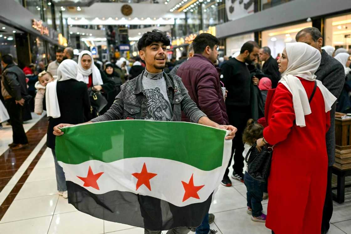 A young man holds a Syrian independence flag in a shopping mall near Sarmada, in the northern province of Idlib