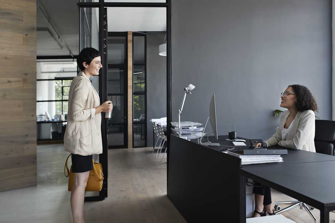 An assistant reporting to her boss in an office