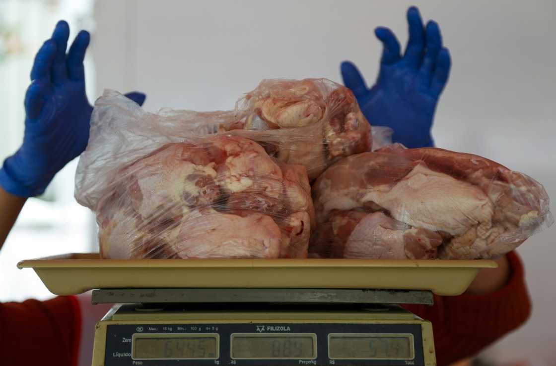 A salesperson weighs chicken at a street market in Sao Paulo, Brazil, on August 25, 2022