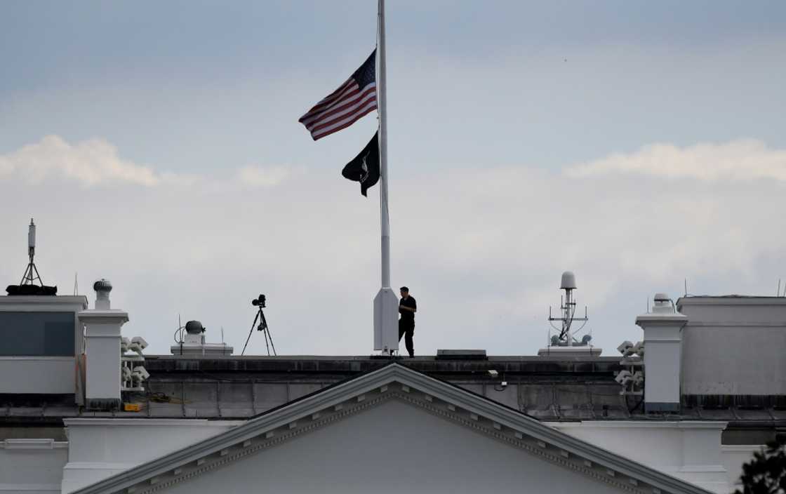 A man lowers the US flag above the White House to half-staff following the death of Queen Elizabeth II A man lowers the US flag above the White House to half-staff following the death of Queen Elizabeth II