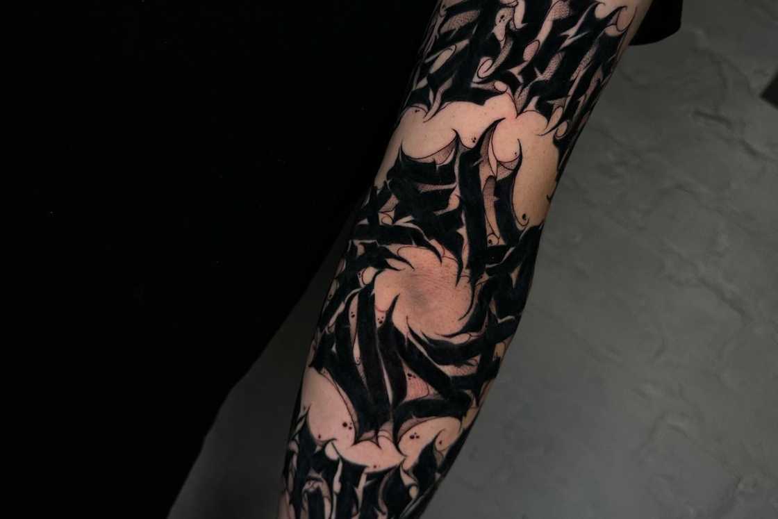 A black freehand cover-up elbow body art A black freehand cover-up elbow body art