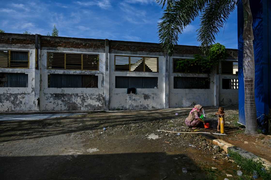 A Rohingya refugee baths a child at a temporary shelter in Banda Aceh in January 2024, part of a wave of more than 1,500 refugees arriving in Indonesia in recent months