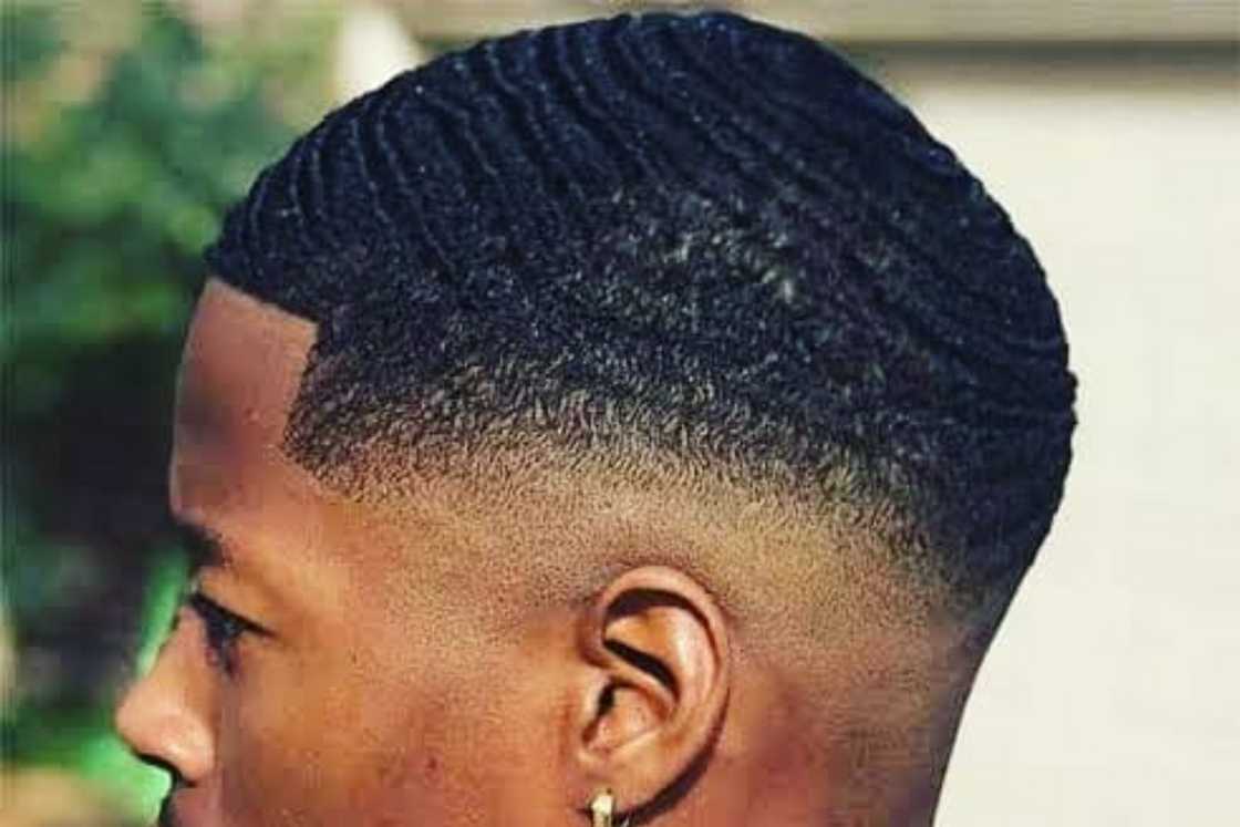 A black hair finger wave with a mid taper fade