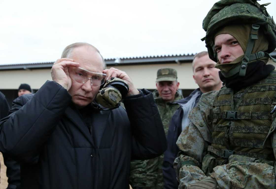 Russian President Vladimir Putin (L) meets soldiers during a visit at a military training centre of the Western Military District for mobilised reservists, outside the town of Ryazan on October 20, 2022. Russian President Vladimir Putin (L) meets soldiers during a visit at a military training centre of the Western Military District for mobilised reservists, outside the town of Ryazan on October 20, 2022.
