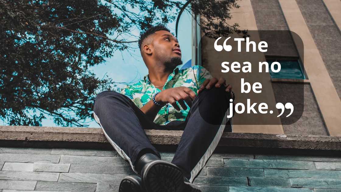 A young man sitting on a ledge outdoors, looking off to the side. A young man sitting on a ledge outdoors, looking off to the side.