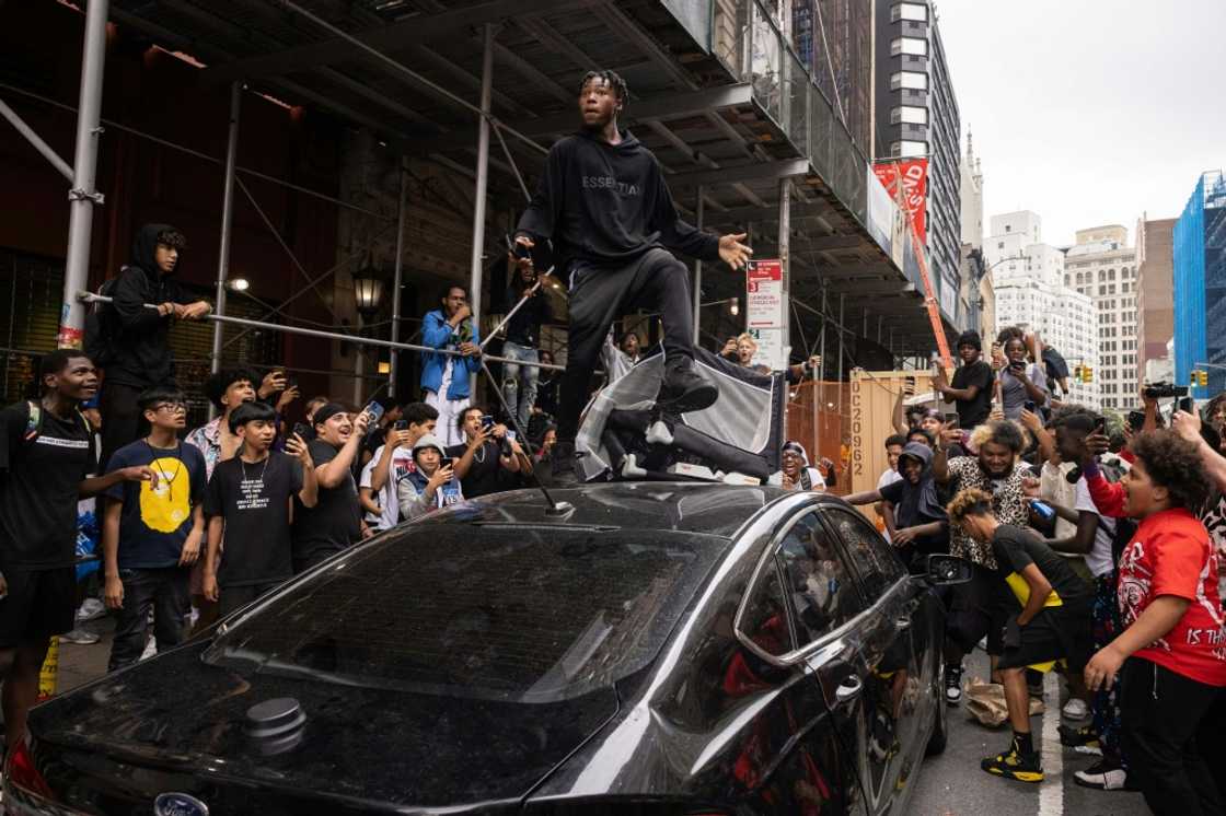 A person jumps on a car during riots sparked by Twitch streamer Kai Cenat, who announced a "givaway" event, in New York's Union Square on August 4, 2023 A person jumps on a car during riots sparked by Twitch streamer Kai Cenat, who announced a "givaway" event, in New York's Union Square on August 4, 2023