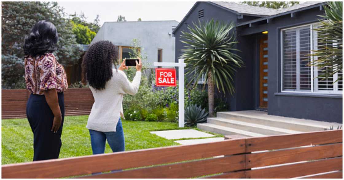 A property owner (left) receives a prospective buyer for her house