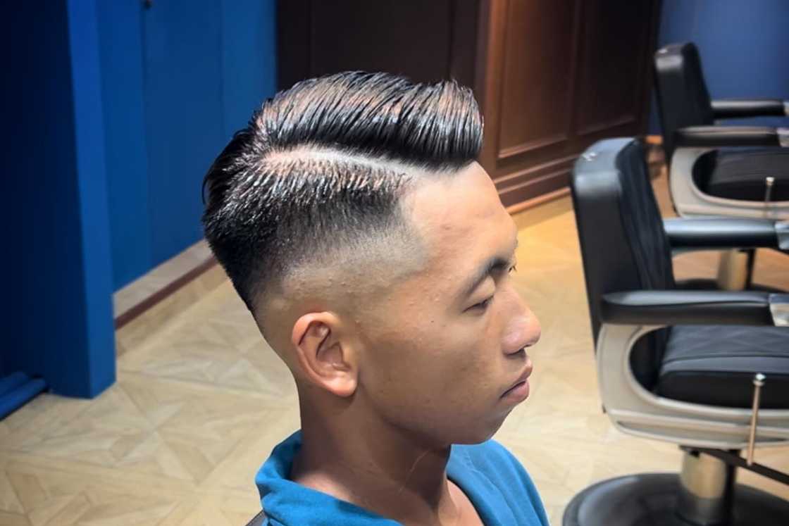 A man rocks a high fade cut with side part A man rocks a high fade cut with side part