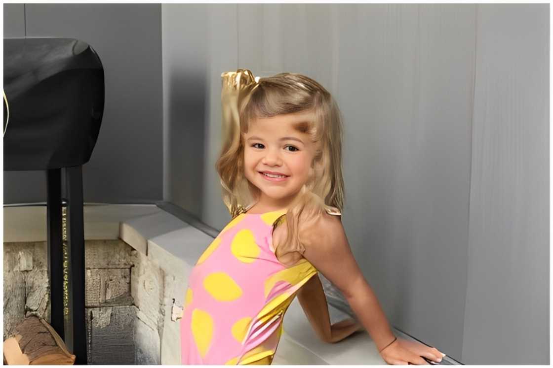 Ada James Akins leaning against a pony wall. Ada James Akins leaning against a pony wall.