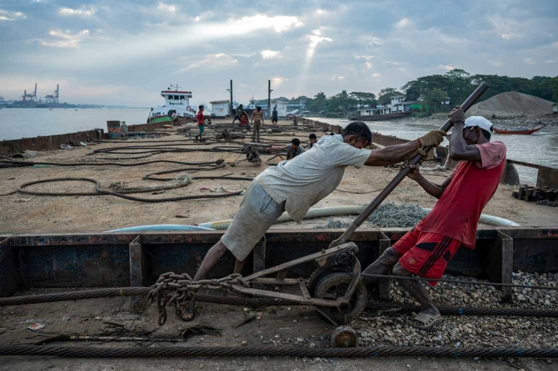 Workers attach cables to the sunken ships, then slowly tighten them after each tide raises the wreck, bringing it into shallower waters nearer the shore Workers attach cables to the sunken ships, then slowly tighten them after each tide raises the wreck, bringing it into shallower waters nearer the shore