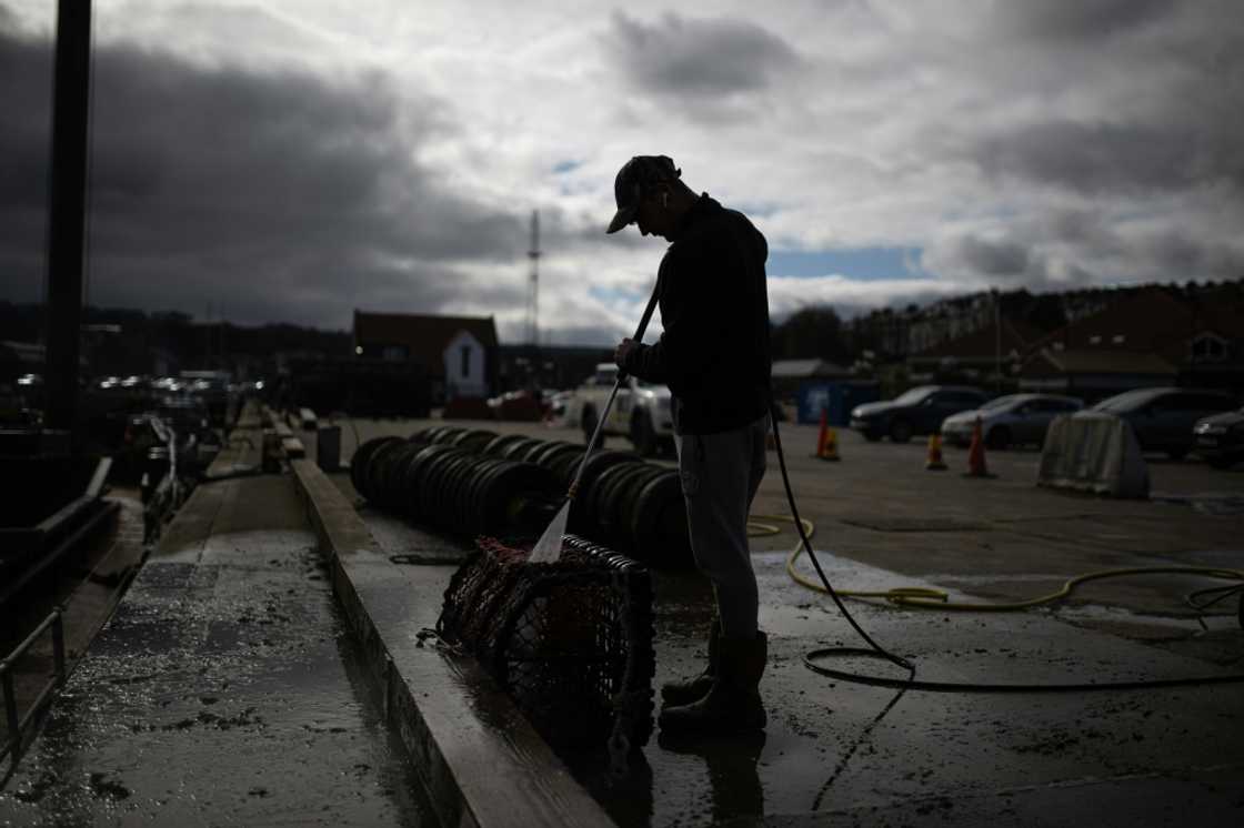 Deck hand Ben Hinchley cleans lobster pots before heading out to sea off Whitby Deck hand Ben Hinchley cleans lobster pots before heading out to sea off Whitby