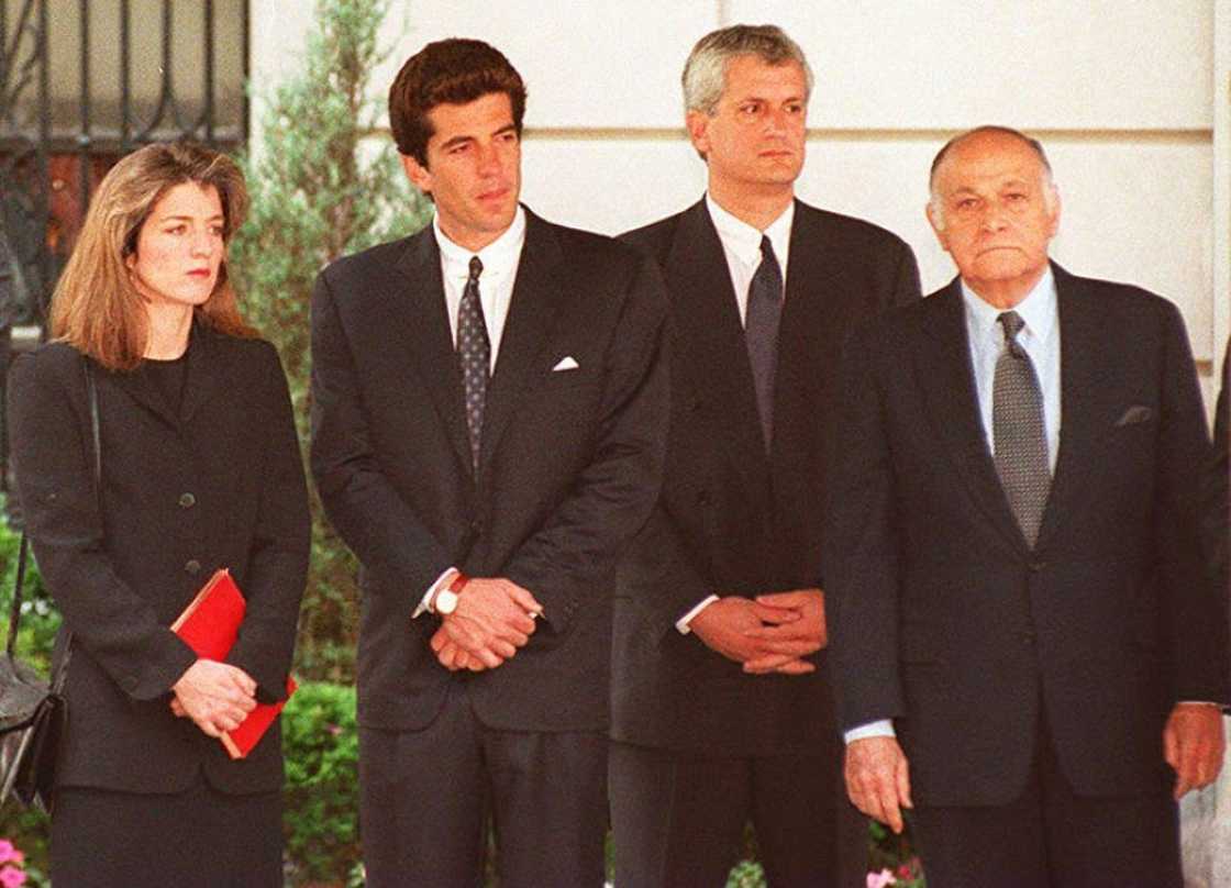 Caroline Kennedy Schlossberg, John F. Kennedy Jr., Edwin Scholssberg and Maurice Tempelsman (L-R) watched together as the casket containing the body of Jacqueline Kennedy Onassis was placed in a hearse in 1994