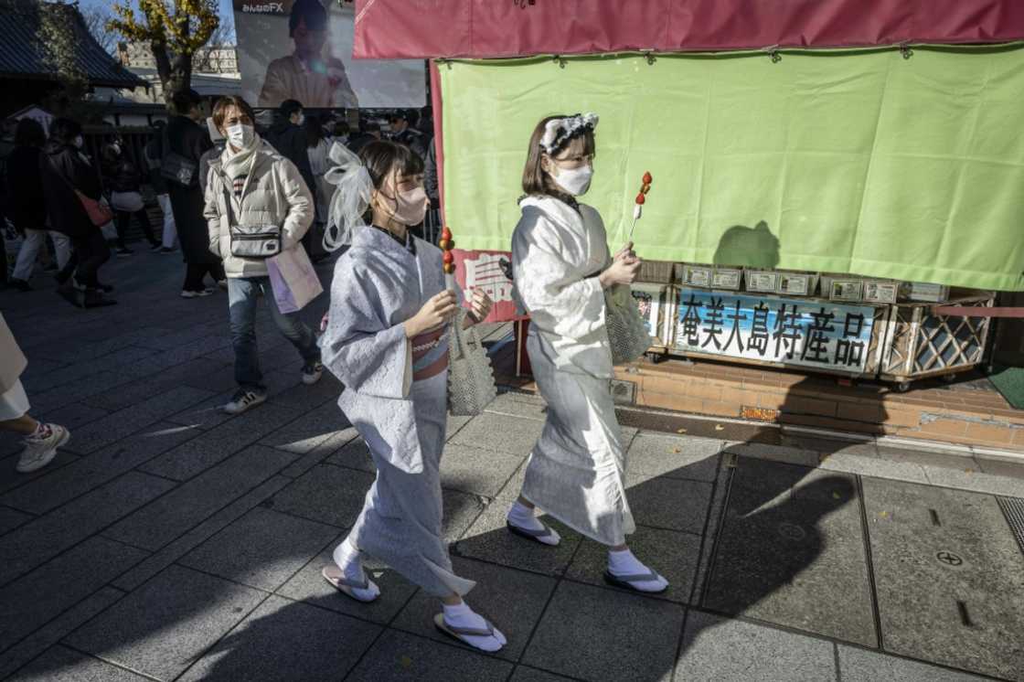 Women wearing Japanese kimonos walk through the Nakamise shopping street near Tokyo's Sensoji Temple on Thursday Women wearing Japanese kimonos walk through the Nakamise shopping street near Tokyo's Sensoji Temple on Thursday