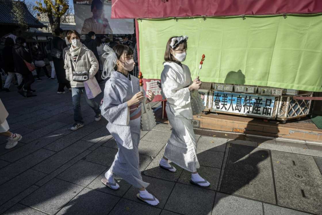 Women wearing Japanese kimonos walk through the Nakamise shopping street near Tokyo's Sensoji Temple on Thursday
