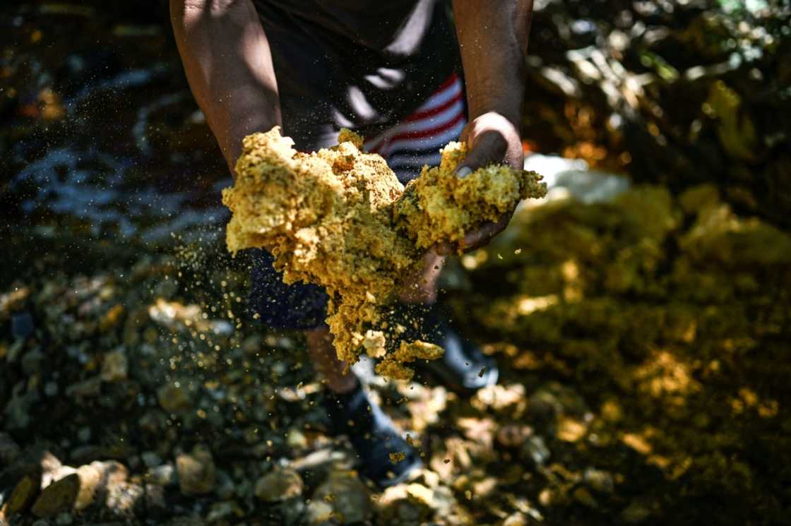 A man shows chemical waste taken from the San Sebastian River, contaminated by mining activity, in Santa Rosa de Lima, La Union department, El Salvador, on December 5, 2024