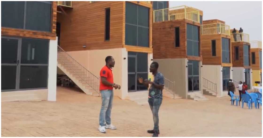 Tuger (in orange shirt) holding discussions with Zion Felix in front of his container houses