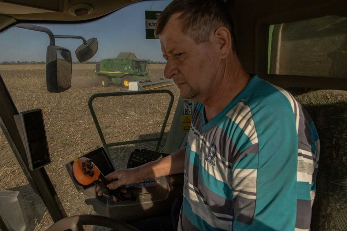 A worker drives a combine harvester collecting sunflower seeds near Kryvyi Rig A worker drives a combine harvester collecting sunflower seeds near Kryvyi Rig