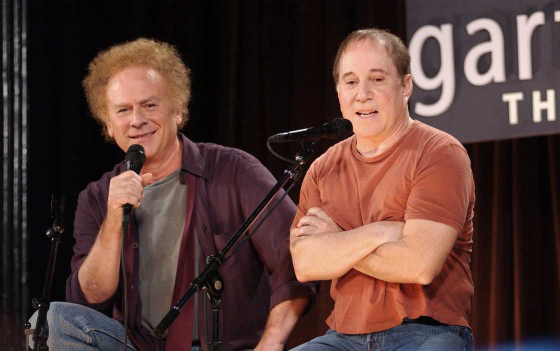 Art Garfunkel (L) and Paul Simon (R) speak onstage Art Garfunkel (L) and Paul Simon (R) speak onstage