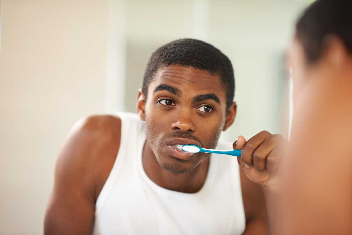 A young man brushing his teeth A young man brushing his teeth
