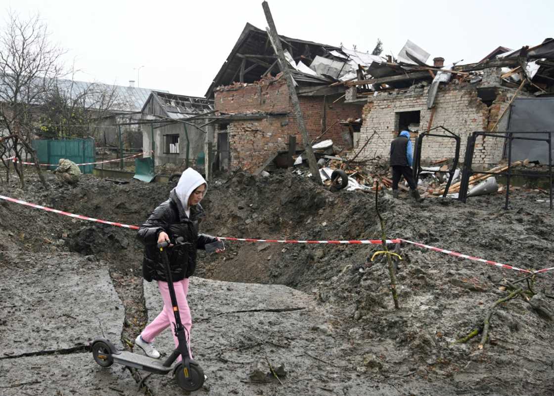 A girl walks her scooter past a crater after a Russian missile strike in a village near the western Ukrainian city of Lviv A girl walks her scooter past a crater after a Russian missile strike in a village near the western Ukrainian city of Lviv