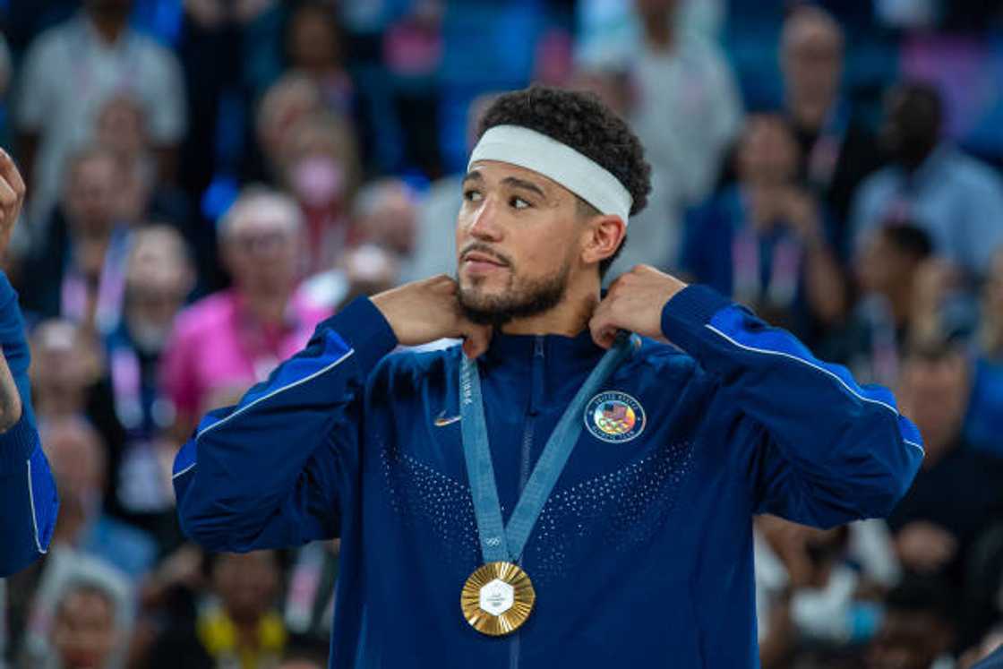 Devin Booker of United States pose for a photo with his gold medal during the Men's Basketball Medal Ceremony at the 2024 Olympic Games in Paris, France.