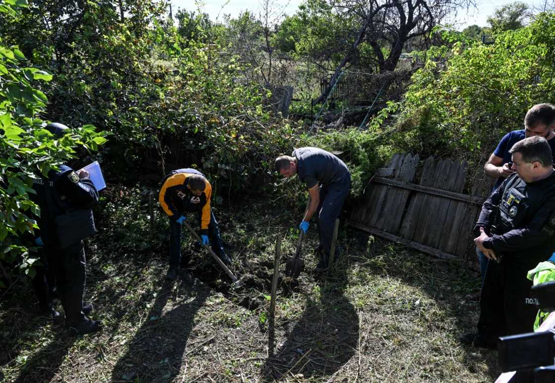 Police and a team from the Kharkiv region's prosecutors office exhumed two bodies