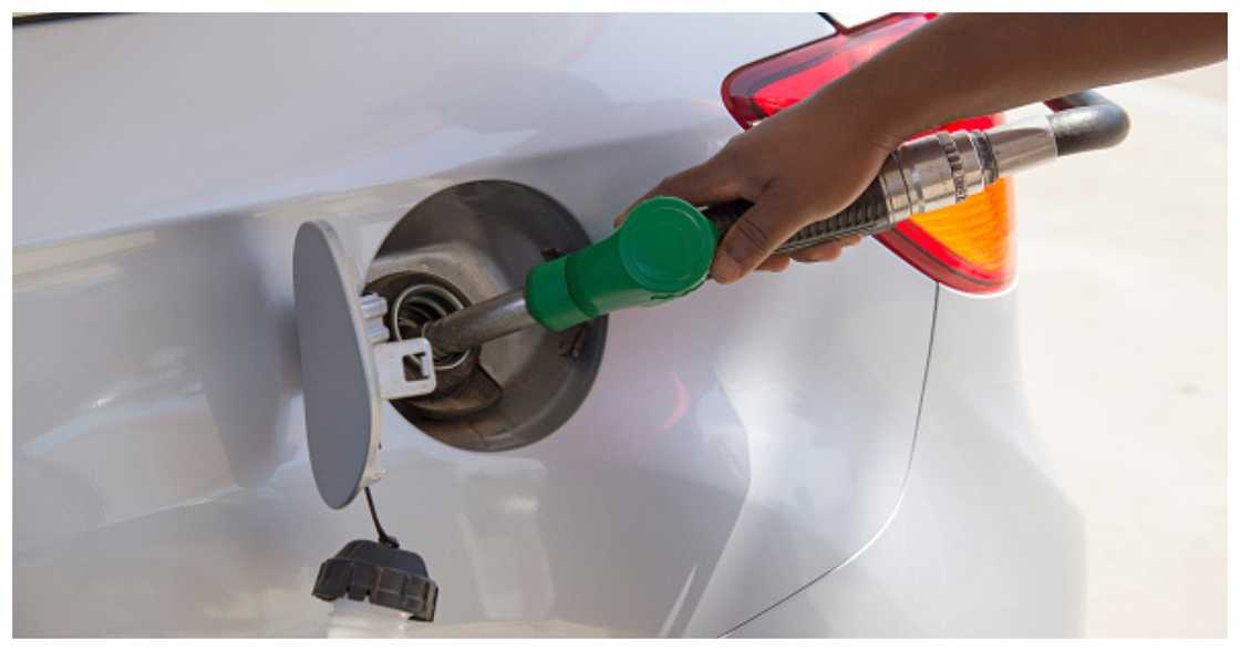 A man puts the nozzle of a fuel pump into the tank of a car. Source: Getty Images