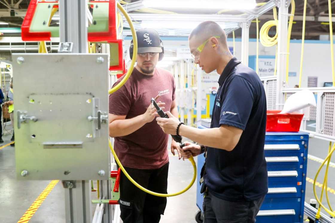 Instructor Andy Tran (R) works with Dmitriy Rudenko on a 90-degree motor at the Boeing Foundational Training Center in Renton, Washington