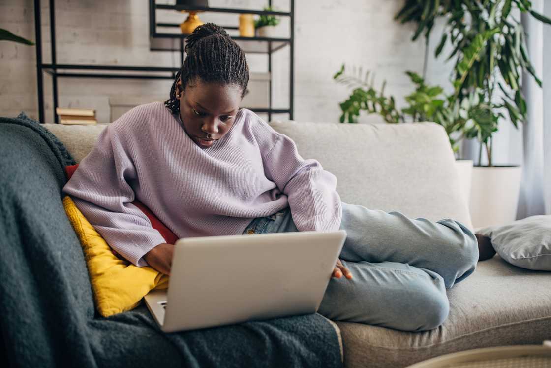 A woman scrolls on her laptop