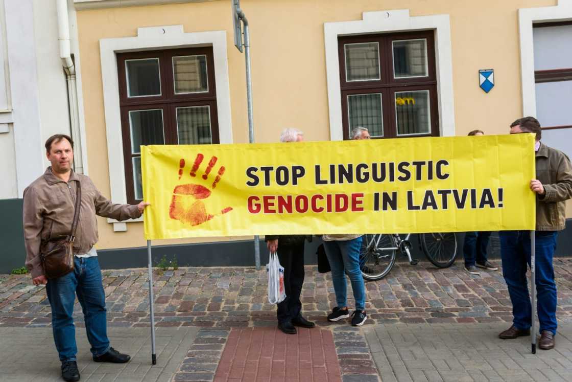 People hold a banner to protest language reforms which Latvia's Russian-speaking miniroty say are increasing their cultural marginalisation People hold a banner to protest language reforms which Latvia's Russian-speaking miniroty say are increasing their cultural marginalisation