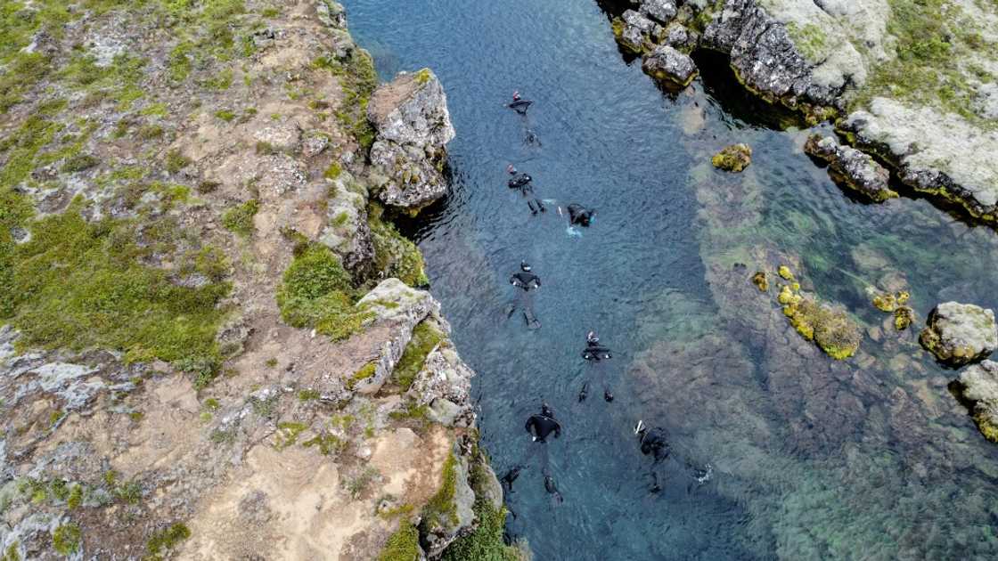 Taking a dip in Silfra requires a lot of preparation: dry suit, diving gloves, swimming hat, mask, snorkel, and fins