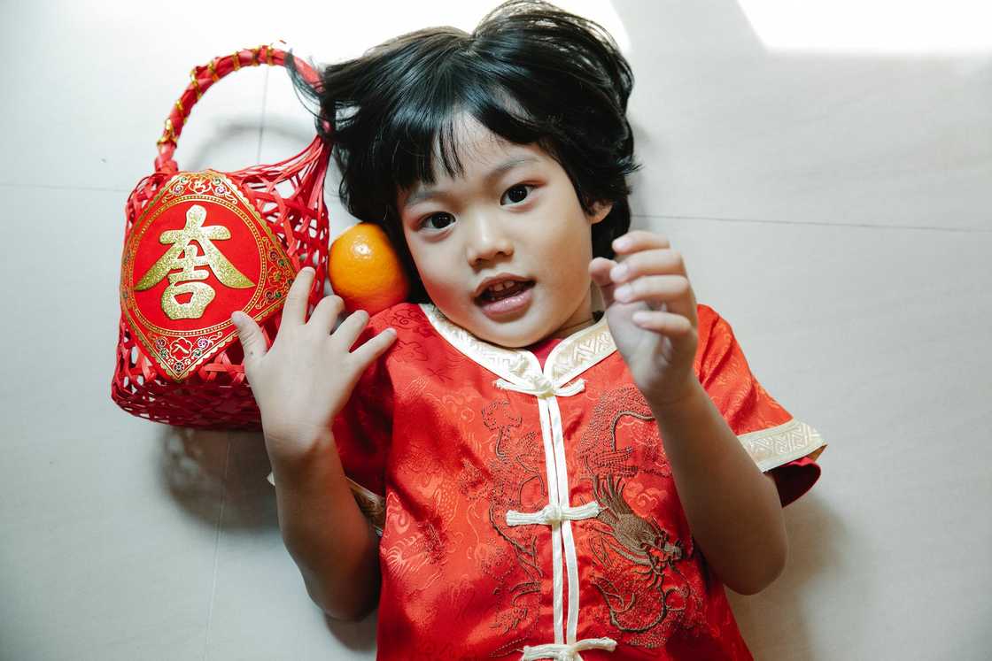 A child in red clothing lying down on the floor A child in red clothing lying down on the floor