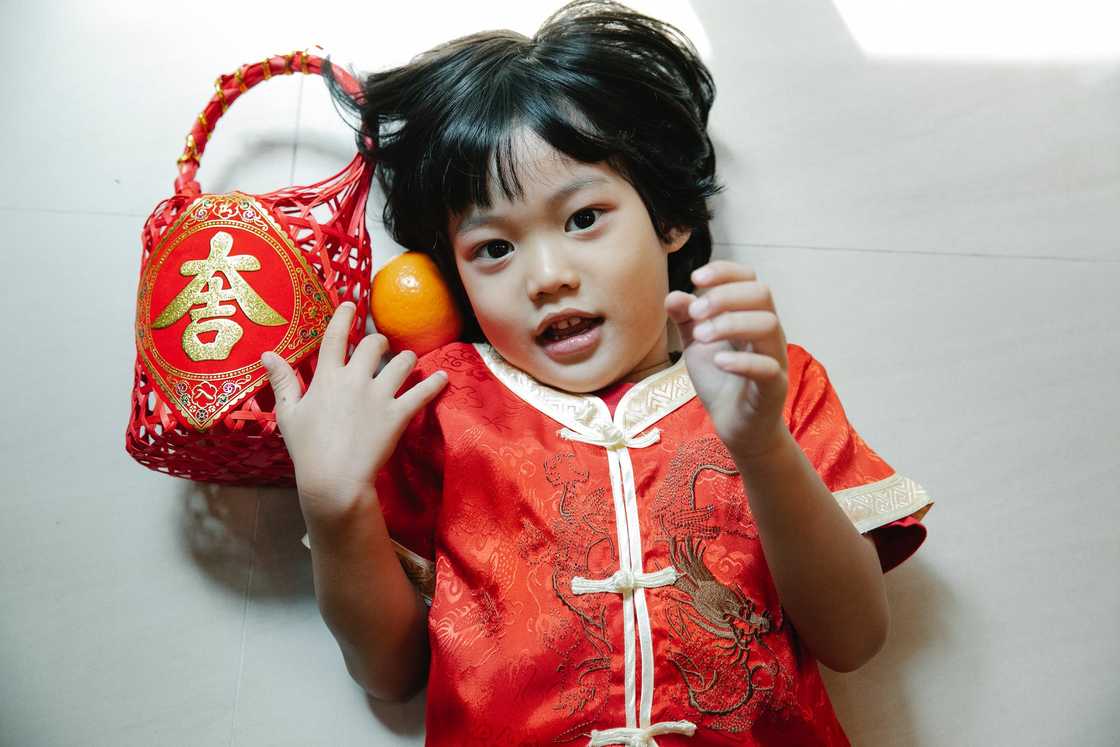 A child in red clothing lying down on the floor