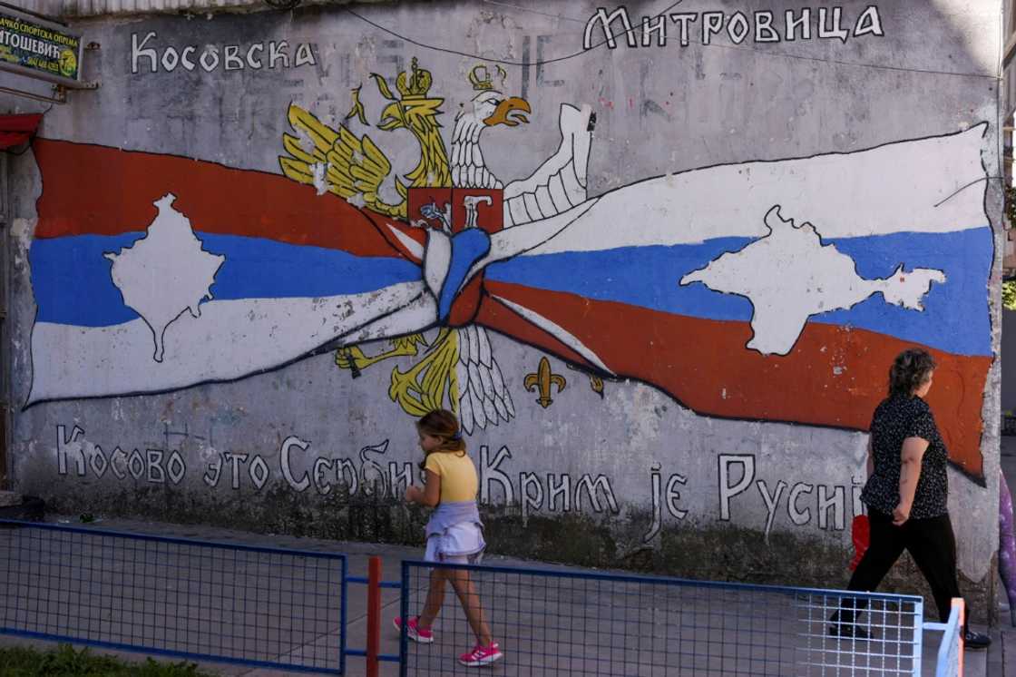 A child walks by a mural reading 'Kosovo is Serbia -- Crimea is Russia' in a Serb part of Mitrovica, Kosovo A child walks by a mural reading 'Kosovo is Serbia -- Crimea is Russia' in a Serb part of Mitrovica, Kosovo