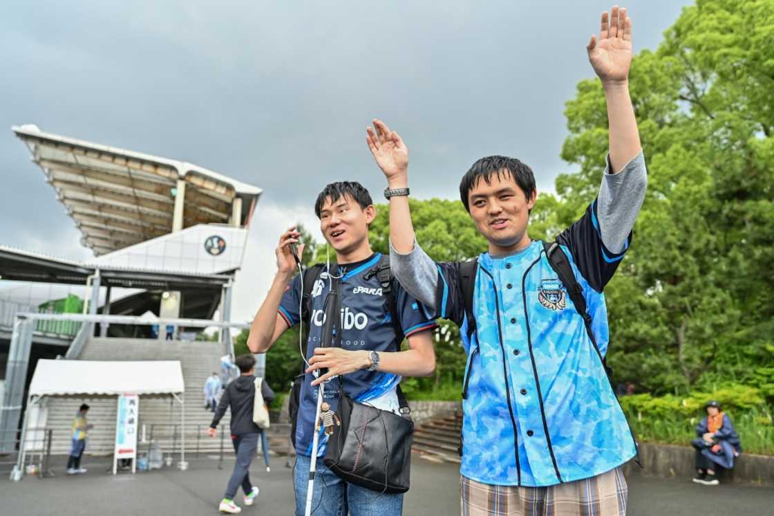 Mashiro (L) cheering with his friend after they arrive at a stadium using an app with ChatGPT for directions Mashiro (L) cheering with his friend after they arrive at a stadium using an app with ChatGPT for directions