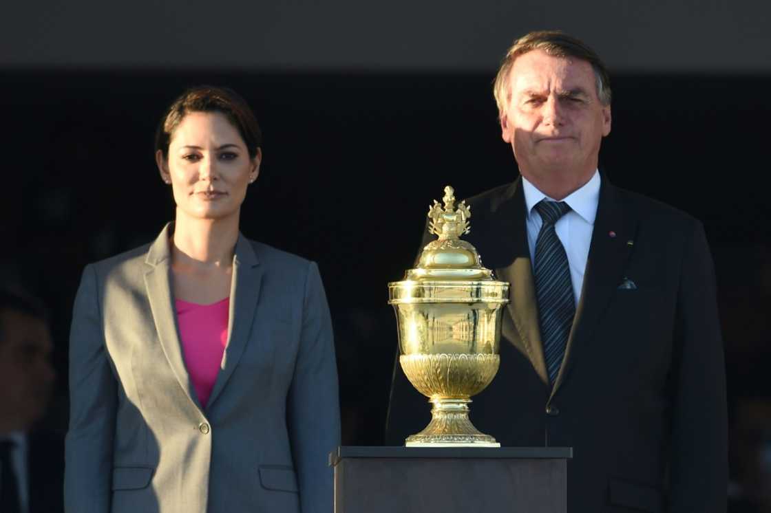 Le président brésilien Jair Bolsonaro (D) aux côtés de son épouse Michelle (G), avec la relique du coeur de l'empereur Pierre 1er, exposée à Brasilia à l'occasion du bicentenaire de l'Indépendance, le 24 août 2022