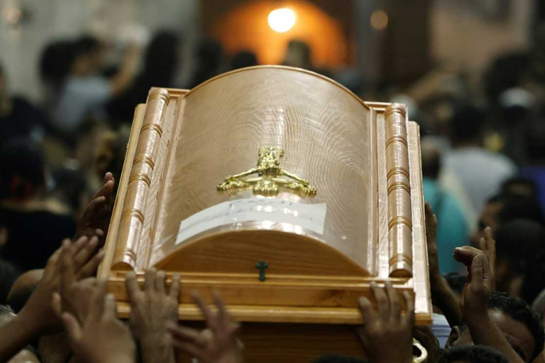 Egyptian mourners carry the coffin of a child killed in the Cairo Coptic church fire at the Church of the Blessed Virgin Mary in Giza Governorate on August 14, 2022 Egyptian mourners carry the coffin of a child killed in the Cairo Coptic church fire at the Church of the Blessed Virgin Mary in Giza Governorate on August 14, 2022