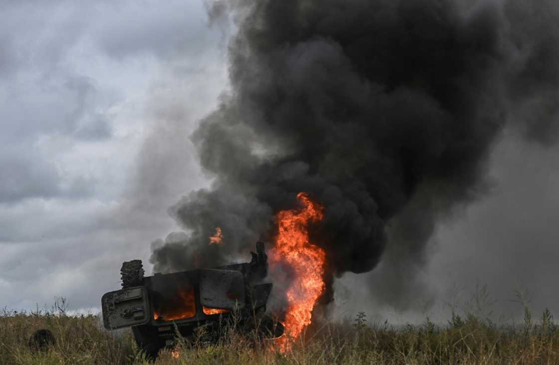 A military vehicle burns outside of the Izyum, a city recaptured by Ukraine troops