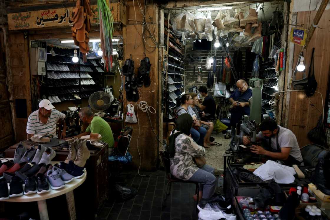 Workers repair shoes as customers wait in Ahmed al-Bizri's store in Lebanon's coastal city of Sidon Workers repair shoes as customers wait in Ahmed al-Bizri's store in Lebanon's coastal city of Sidon