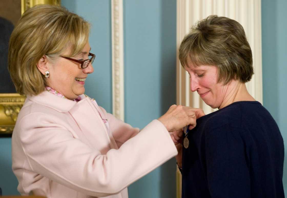 US Secretary of State Hillary Clinton presents Lynne Tracy (R) with the Secretary's Award for Heroism in 2009, after Tracy spent three years in Peshawar, Pakistan where she survived a violent attack by gunmen while she was riding in her official car