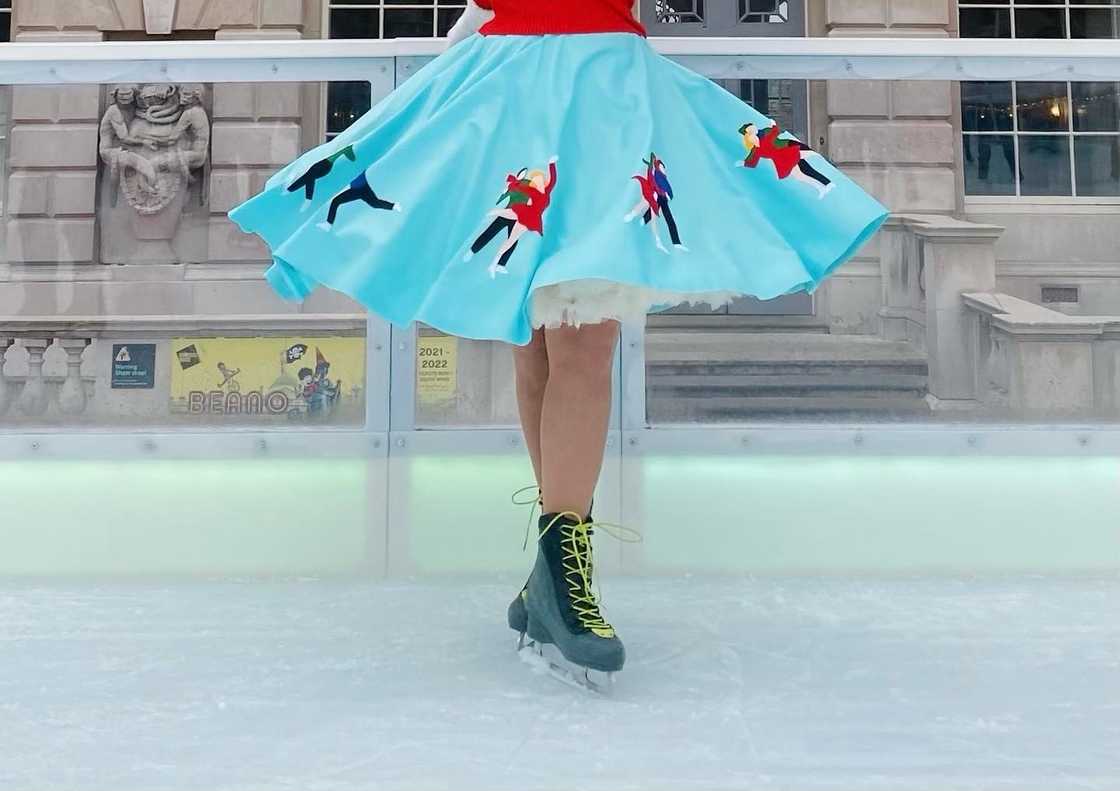 A woman with a red top wears an ocean-blue circular skirt A woman with a red top wears an ocean-blue circular skirt