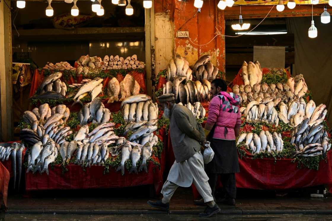 A man walks past a fish market in Rawalpindi. Pakistan's economy is in the doldrums, with soaring inflation, a weak rupee, and dwindling forex reserves A man walks past a fish market in Rawalpindi. Pakistan's economy is in the doldrums, with soaring inflation, a weak rupee, and dwindling forex reserves