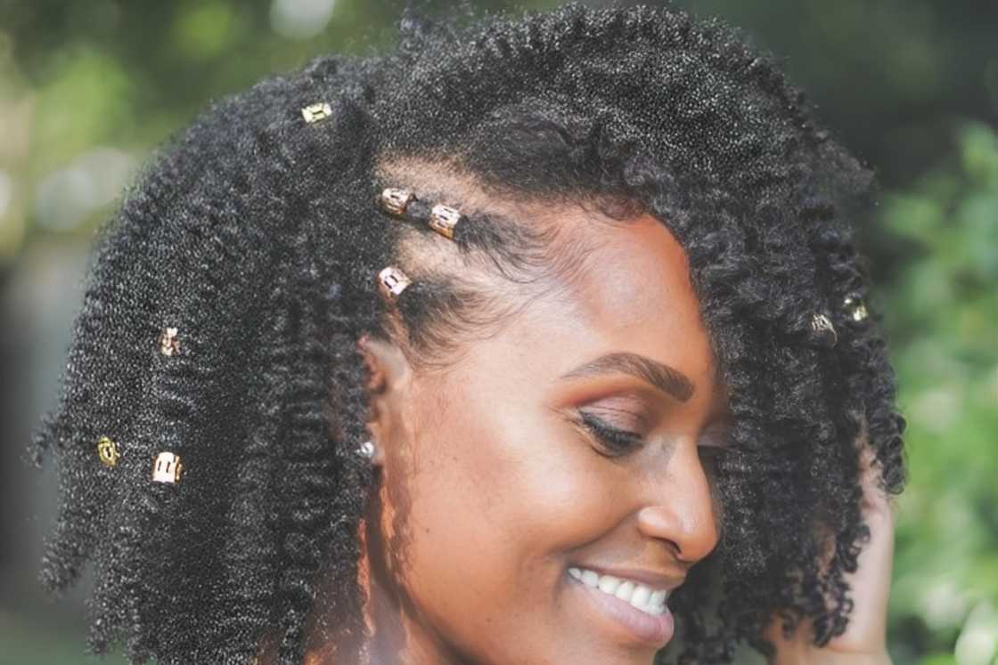 A black woman is rocking a natural twist-out hairstyle