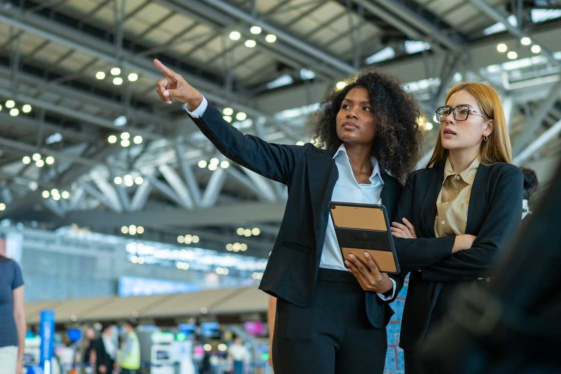 Airport terminal; woman and agent standing side-by-side.