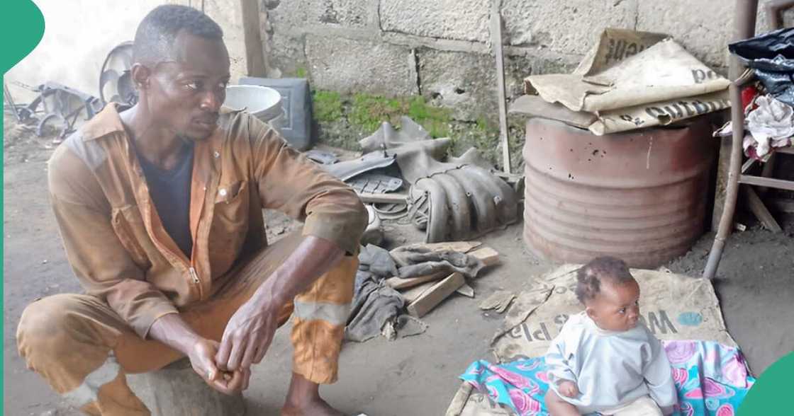 Nigerian mechanic caring for his baby. Nigerian mechanic caring for his baby.
